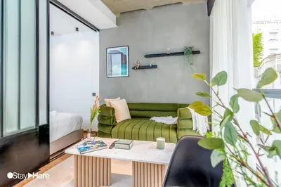 a living room with a green couch and a table at Stayhere Casablanca - Gauthier 1 - Modern Residence in Casablanca