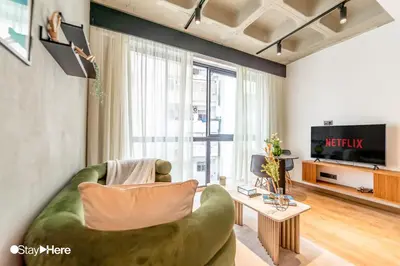 a living room with a green couch and a tv at Stayhere Casablanca - Gauthier 1 - Modern Residence in Casablanca