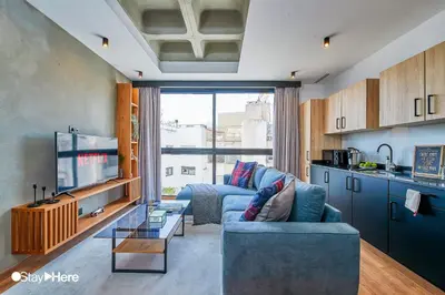a living room with a blue couch and a tv at Stayhere Casablanca - Gauthier 1 - Modern Residence in Casablanca