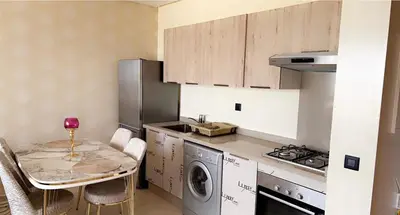 a kitchen with a table and a washing machine at Studio de luxe à casa finance city in Casablanca