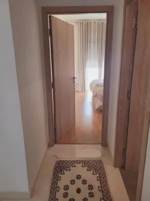 a hallway with an open door to a room with a rug at Luxury in the heart of Hay Riad in Rabat