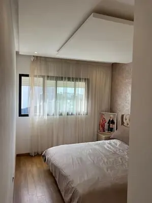 a bedroom with a large bed and a window at Superbe appartement avec piscine in Rabat