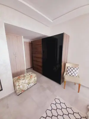 a living room with a chair and a ottoman at Superbe Appartement Bouskoura in Bouskoura