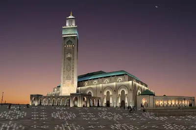 a large building with a clock tower at night at Appartement Casablanca Anfa in Casablanca