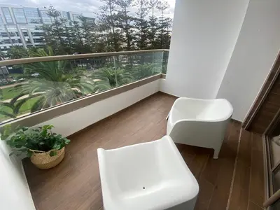 a balcony with a white chair and a toilet at Luxueux appartement avec vue panoramique WELCOME STAY in Mohammedia