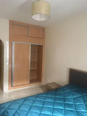 a bedroom with a blue bed and a window at Au centre de Agdal in Rabat
