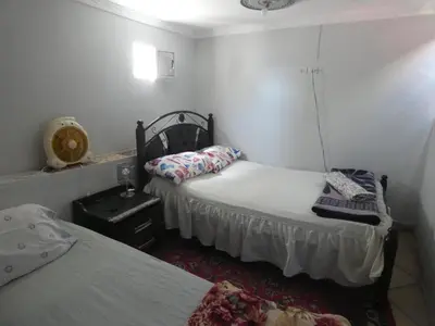a room with two beds and a lamp and a table at Booking and hosting medina in Casablanca