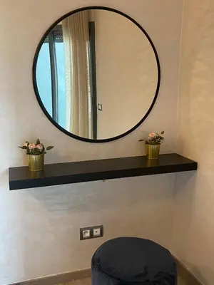 a mirror on a shelf with two potted plants at Miramare Cosy appartement pied dans l'eau avec piscine in Mohammedia