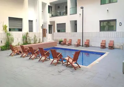 a group of chairs next to a swimming pool at Miramare Cosy appartement pied dans l'eau avec piscine in Mohammedia