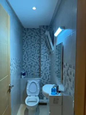 a small bathroom with a toilet and a sink at Appt front la mer in Rabat
