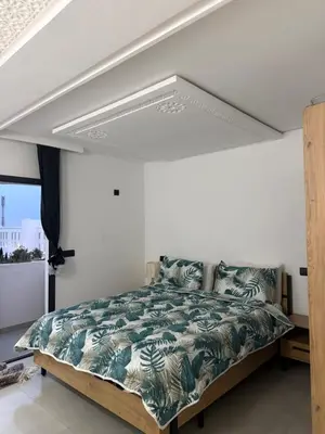 a bedroom with a large bed with a canopy at Appt 1 ch salon for saison in Rabat