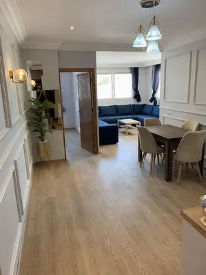 a living room with a table and a blue couch at Chic & Cozy Studio Centre Ville Super Propre in Casablanca