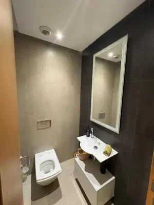a bathroom with a toilet and a sink and a mirror at Marina Casa Del Mar - Amazing Sea & Mosque views in Casablanca