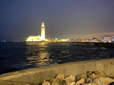 a city with a clock tower on the water at night at appartement en plein centre de casablanca in Casablanca