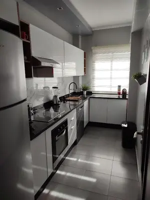 a kitchen with white cabinets and a stove top oven at Chaleureux Appartement à 1 min à pied de la Mosquée Hassan II in Casablanca