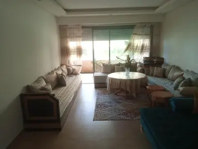 a living room with a couch and a table at Apparemment Rockisland in Mohammedia