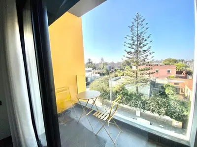 a balcony with a table and chairs and a window at NEW modern 1 BR, 1min fr tramway in Casablanca