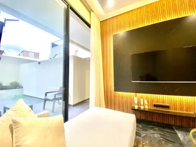 a living room with a large television and a white couch at NEW modern 1 BR, 1min fr tramway in Casablanca