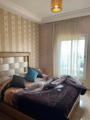a bedroom with a large bed with blue pillows at Ricoflores PALM in O Ben Slimane