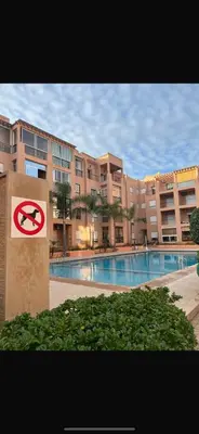 a no swimming pool with a sign in front of a building at Ricoflores PALM in O Ben Slimane