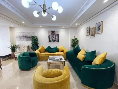a living room with green couches and yellow chairs at High Standing & cozy apartment in central Casablanca in Casablanca