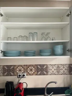 a kitchen counter with plates and dishes on shelves at High Standing & cozy apartment in central Casablanca in Casablanca