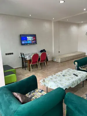 a living room with couches and a table with chairs at Résidence Faouazi in Casablanca