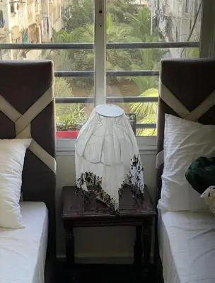 a lamp on a table next to two beds at Appartement calme et confort entier à 10 mn de la corniche, une demie heur de stade d honneur in Casablanca