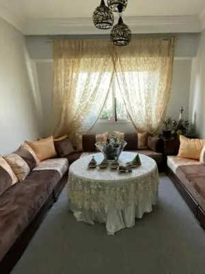 a living room with a couch and a table at Appartement calme et confort entier à 10 mn de la corniche, une demie heur de stade d honneur in Casablanca