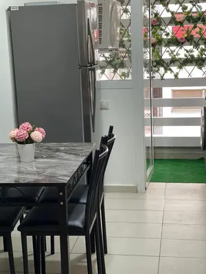a kitchen with a table with chairs and a refrigerator at Superbe Appartement au coeur de Casablanca in Casablanca