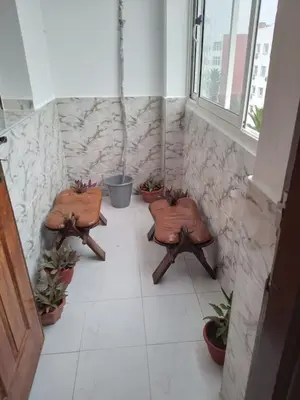 a room with three benches and potted plants at Bel appartement quartier Bourgogne in Casablanca