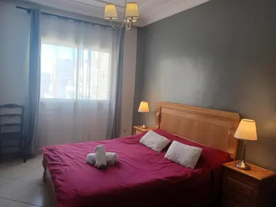 a teddy bear sitting on top of a red bed at Grand appartement lumineux avec balcon & parking idéal familles et pro in Casablanca