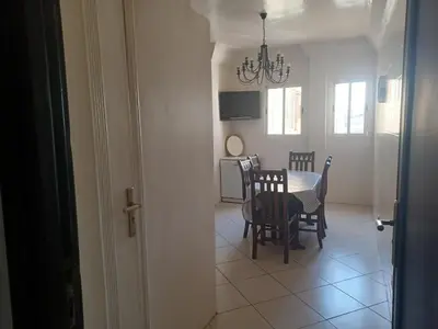 a dining room and kitchen with a table and chairs at Grand appartement lumineux avec balcon & parking idéal familles et pro in Casablanca