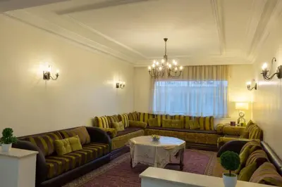 a living room with couches and a table at Grand appartement lumineux avec balcon & parking idéal familles et pro in Casablanca