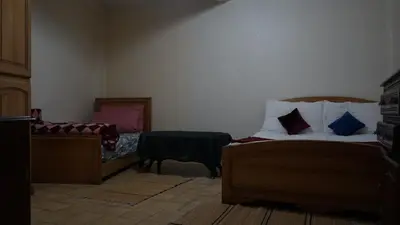 a room with two beds and a table in it at Auberges Des Jeunes Casablanca in Casablanca