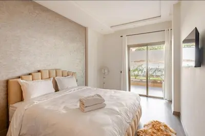a bedroom with a large white bed with a window at Luxurious Apt with Pool&Sea View in Pont Blondin