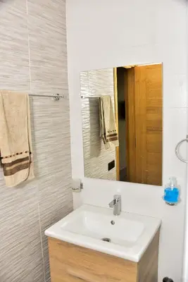 a bathroom with a sink and a mirror at Luxurious Apt with Pool&Sea View in Pont Blondin