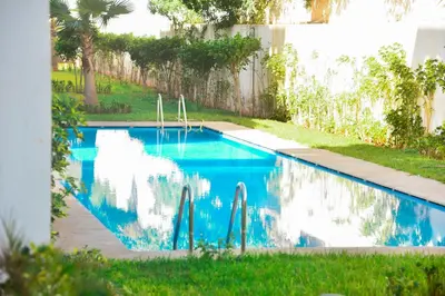 a swimming pool with blue water in a yard at Luxurious Apt with Pool&Sea View in Pont Blondin