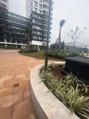 a park with a pole and some plants and buildings at Luxurious Appartement at Casa Finance City in Casablanca