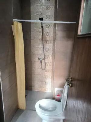 a bathroom with a toilet and a shower with a shower curtain at magnifique appartement à rabat proche de la mer in Rabat