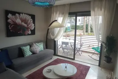 a living room with a couch and a table and a patio at Charmant studio lumineux Casablanca in Bouskoura