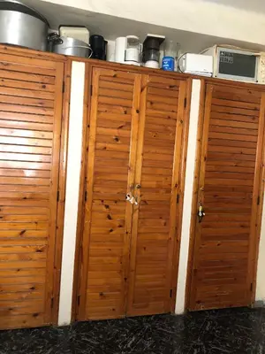 a pair of wooden cabinets in a kitchen at Spacious bedrooms in a traditional house in Rabat
