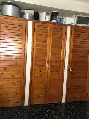a pair of wooden cabinets in a kitchen at Spacious bedrooms in a traditional house in Rabat