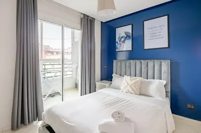 a bedroom with blue walls and a white bed at TT Holidays-Rabat City Center in Rabat