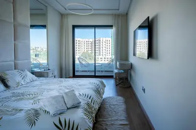 a bedroom with a bed and a large window at Paris-Oasis Casablanca in Casablanca