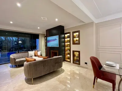 a living room with a couch and a tv at Golf view Villa with Jacuzzi- By AppartAli in Bouskoura