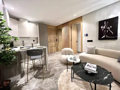 a living room with a couch and a table and a kitchen at Presidential Suite City Center by AppartAli in Casablanca