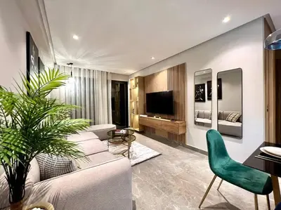 a living room with a white couch and a green chair at Centro 2 Bedrooms- By AppartAli in Casablanca