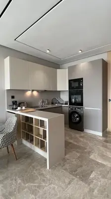 a kitchen with white cabinets and a black appliance at Royal Suite by the Ocean - By Appartali in Casablanca