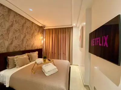 a hotel room with a bed with a television on the wall at La Corniche Garden View - By AppartAli in Casablanca